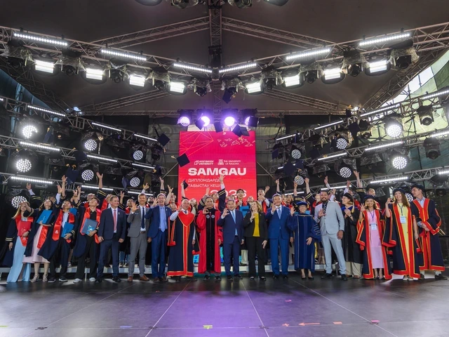 a group of people gathers on a stage at a graduation ceremony