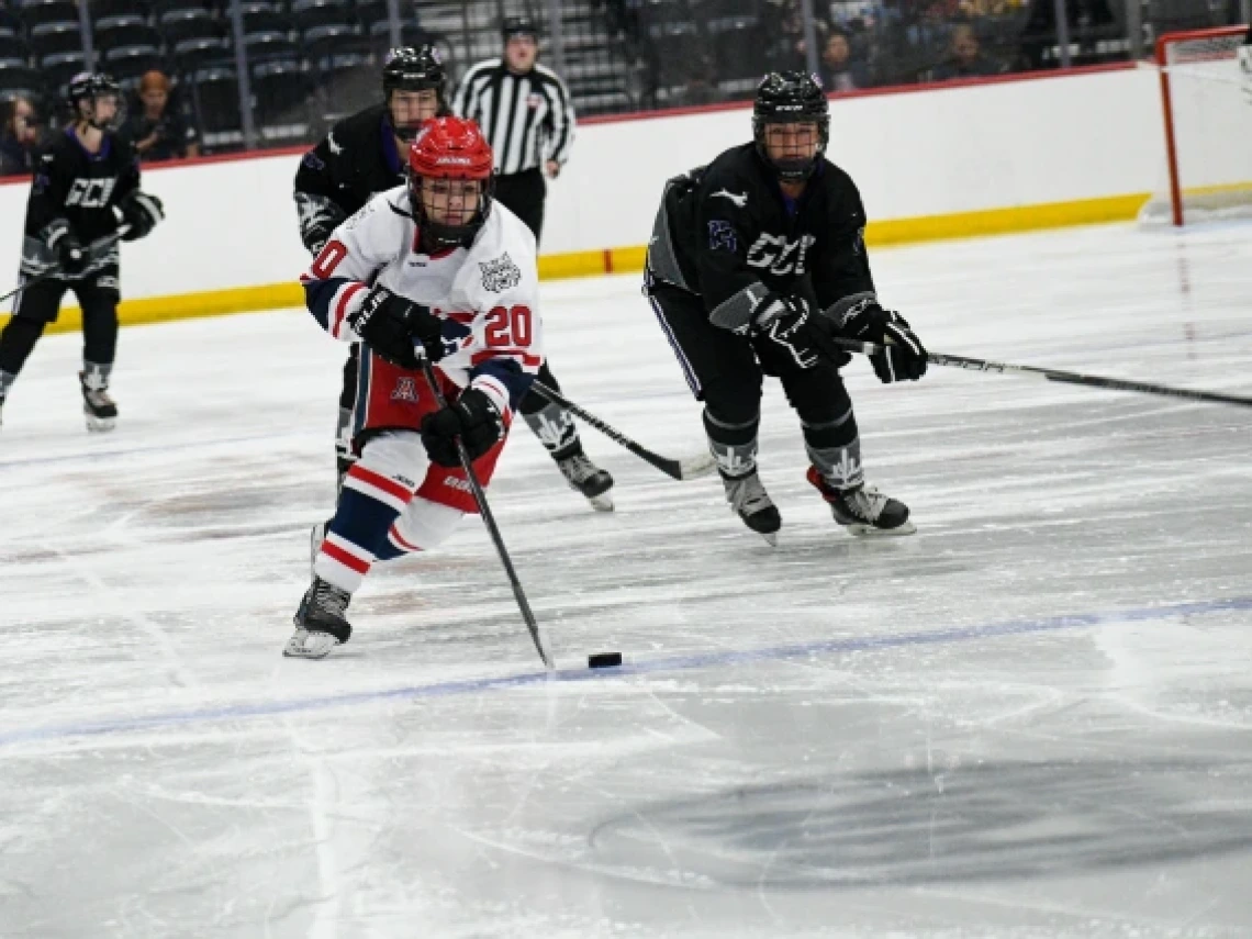 Arizona sophomore forward Teila Saarinen darts past three opponents from Grand Canyon University to grab the puck during the Wildcats first game of the season.