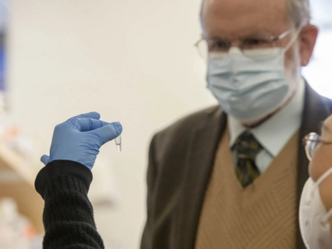 a person holding a vial of liquid