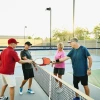 Four older people playing pickleball